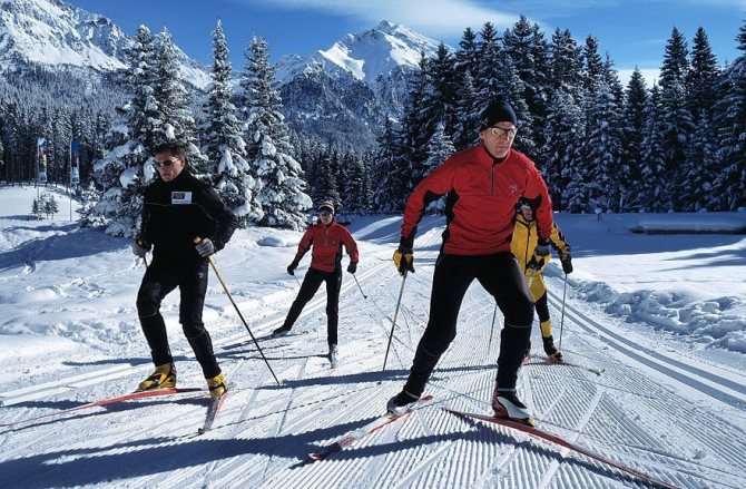 Группа взрослых катаются по ровнойповерхностью на коньковых лыжах