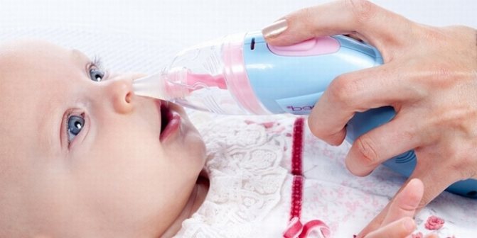Mom cleans her newborn&#39;s nose with an aspirator