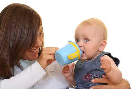 Мама дает ребенку жидкость из детской поилки