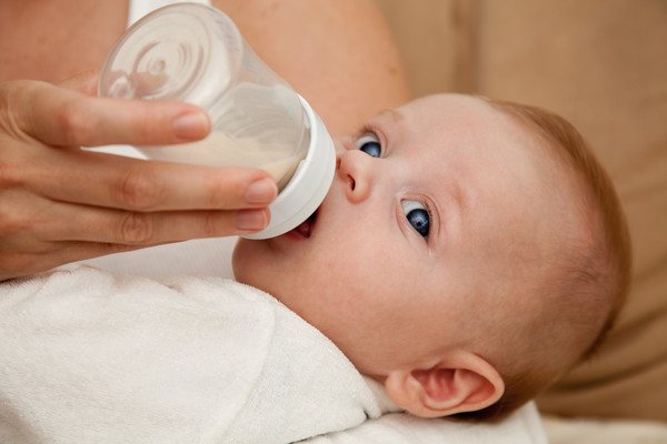 mother feeds baby with bottle