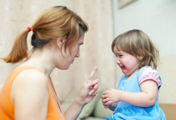 Мама сердито смотрит на дочку, которая плачет