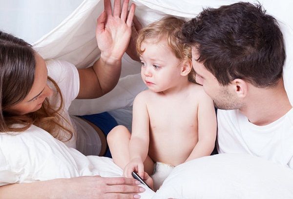 Ребенок с мамой и папой в кровати