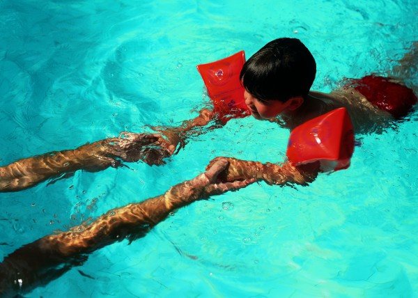 A child in the pool learns to swim - photo
